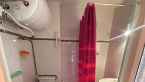 Ein kleines Badezimmer mit Toilette, Waschbecken und Duschbereich.