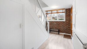 Una escalera conduce a una habitación con pared de ladrillo y ventana.