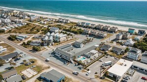An aerial view of a coastal residential area with houses, a beach, and a parking lot. - Loggerhead Inn & Suites - King Premium Suite in hotel in Surf City, North Carolina (Surf City)