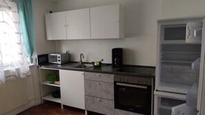 Eine kleine Küche mit Mikrowelle, Toaster, Spüle und kleinem Backofen.
