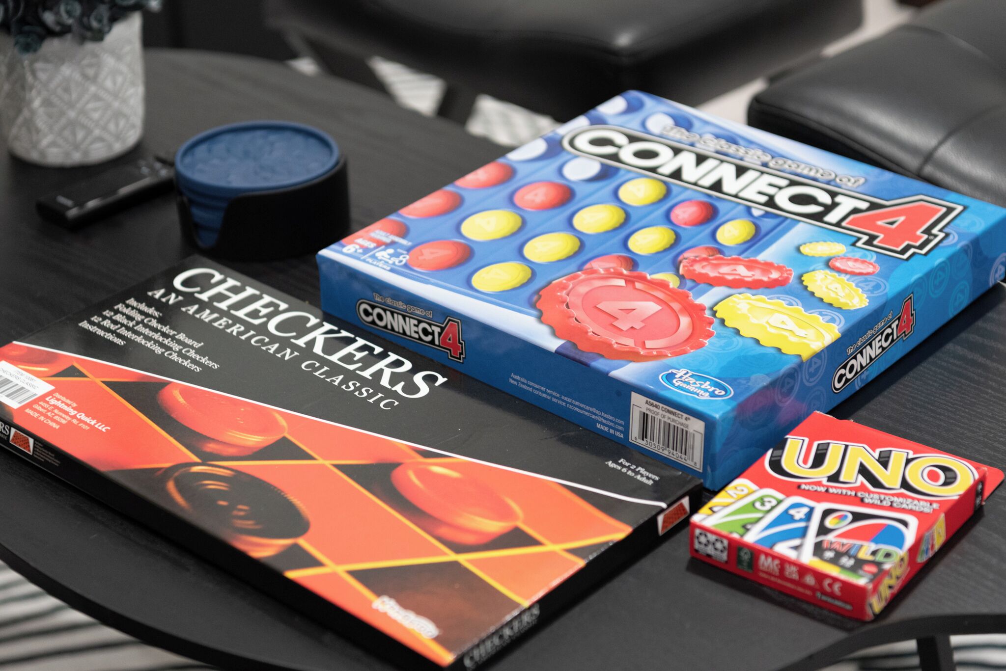 Uma mesa com jogos de tabuleiro como Connect 4, Damas e UNO.