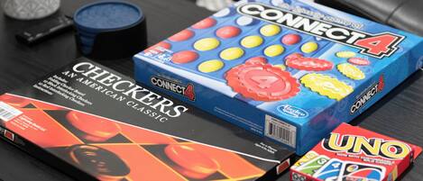 Uma mesa com jogos de tabuleiro como Connect 4, Damas e UNO.
