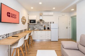 Una cocina moderna con comedor, televisor de pantalla plana y un letrero que dice 'GUEST READY'.