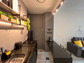 A modern kitchen with a built-in stove, a coffee machine, and a countertop. - Rio Select - Copacabana  (Rio de Janeiro)