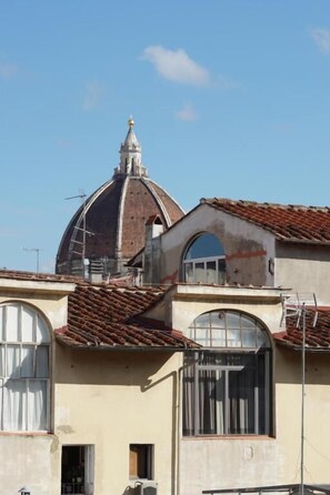 A building with a dome, arched windows, and a tiled roof. - Holiday Rooms (Florence)
