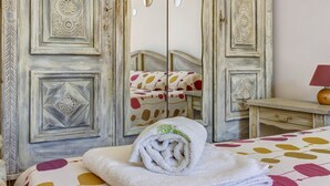 Una habitación con una cama, un espejo y un aparador.