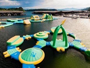 A water park with inflatable play structures and a docked boat.