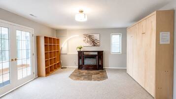 A room with a fireplace, a bookshelf, and a large wooden cabinet.