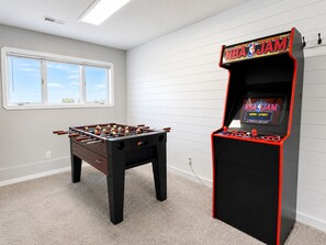 A room with a foosball table and an arcade machine labeled 'NBA JAM.' - Spacious Vernon Retreat w/ Game Room, BBQ Patio & Turf Yard (Vernon)