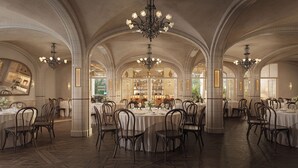 Un amplio comedor con techos altos en arco, múltiples candelabros y una zona de bar central.