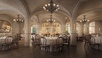 Un amplio comedor con techos altos en arco, múltiples candelabros y una zona de bar central.