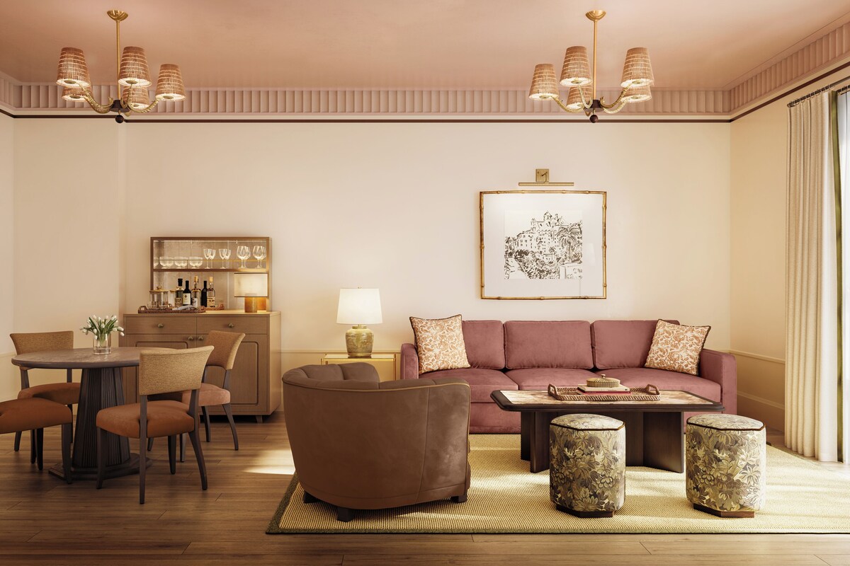 A modern living room with a sofa, coffee table, chairs, and a dining area with a table and chairs.