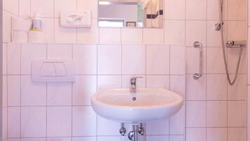 Et badeværelse med toilet, vask og bruser.