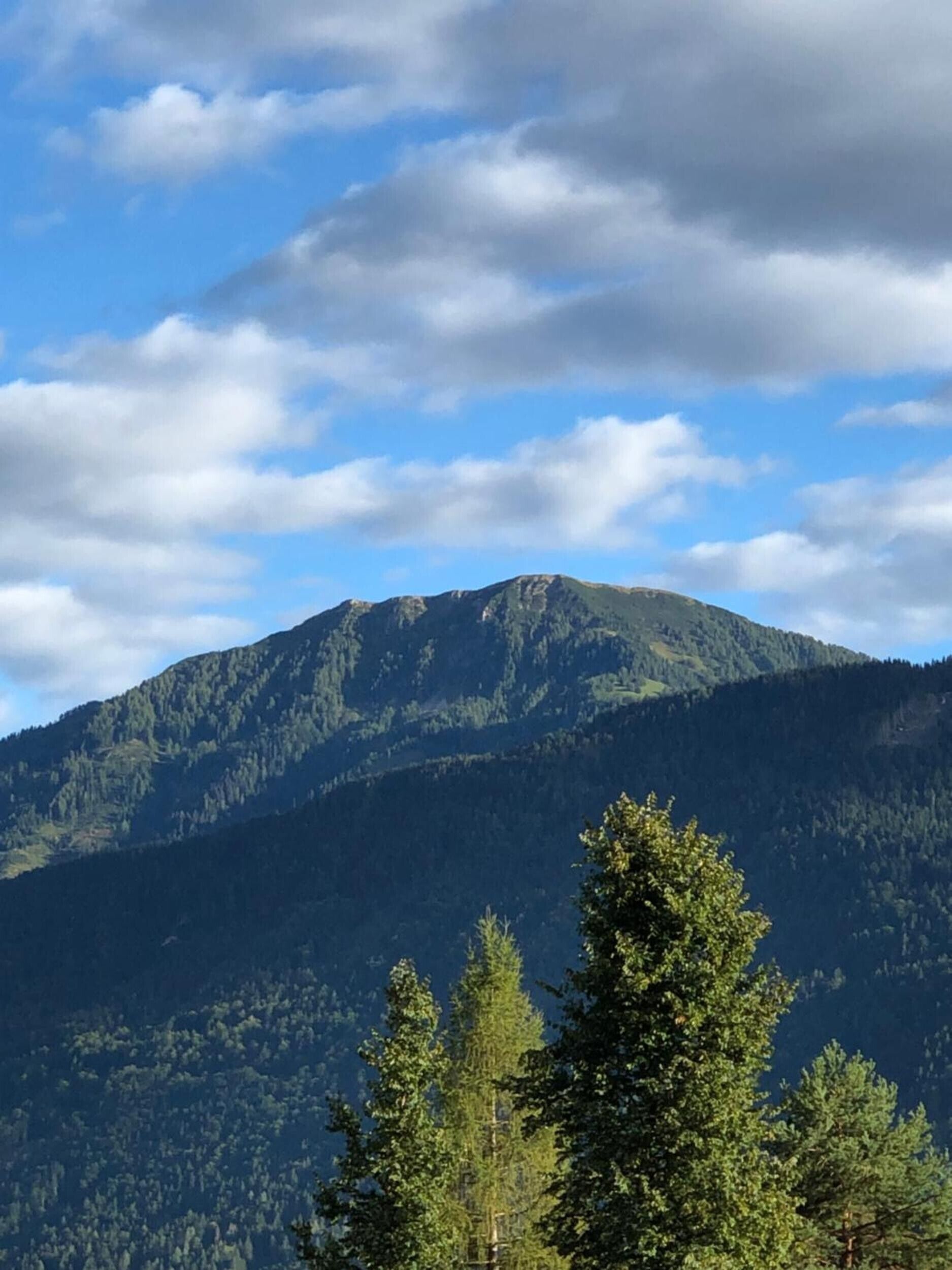 Un paisaje montañoso con cielo despejado y algunas nubes.