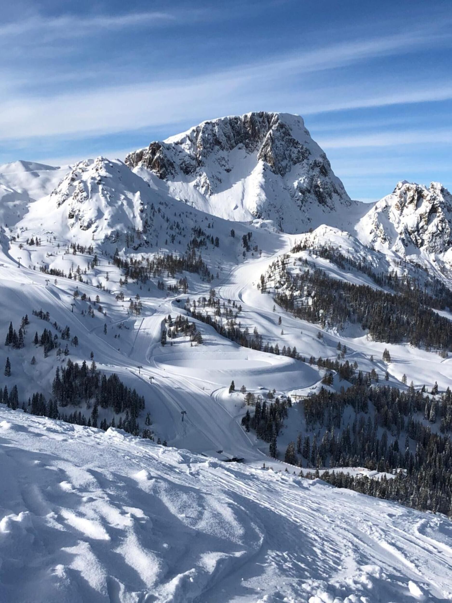 Een besneeuwd berglandschap met skipistes.