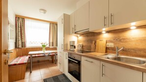 Una cocina compacta con horno integrado, cafetera y pileta.