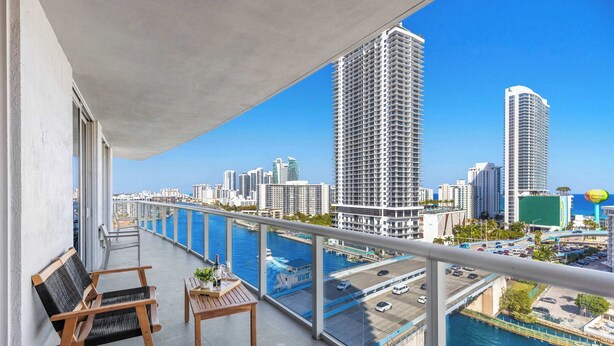 Ein Balkon mit Blick auf einen Yachthafen und hohe Gebäude.