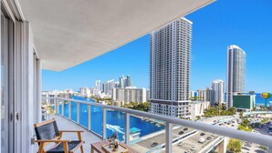 A balcony with a view of a city skyline, a marina, and a hotel building. - Beautiful Apt w/ Private Balcony + Incredible Pool (Hallandale Beach)