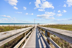 A wooden boardwalk leading to a beach with a clear sky and distant horizon. - Sunswept 201 (Orange Beach)