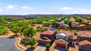 A residential area with houses, a clear sky, and distant mountains.