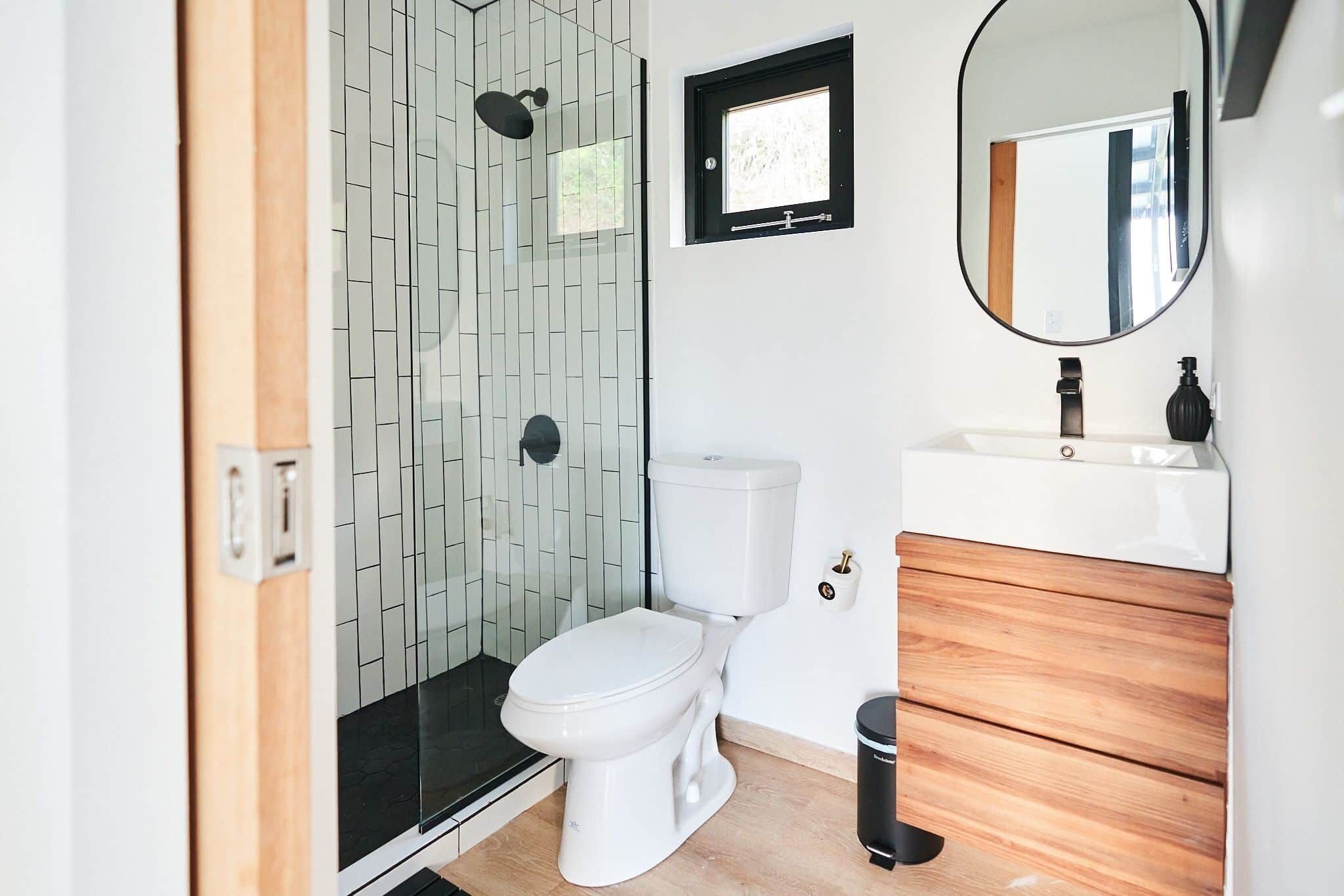 A modern bathroom with a shower, toilet, and sink.