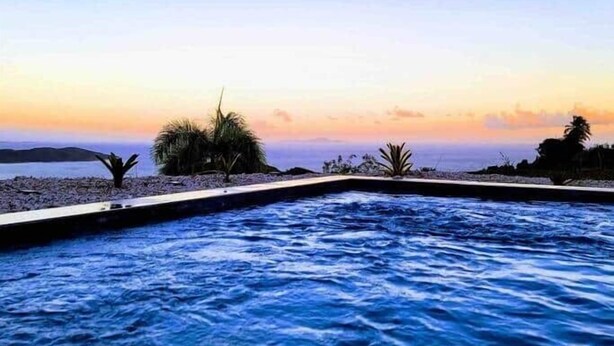 Une piscine avec vue sur l’océan et sur le coucher de soleil.