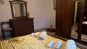 Une chambre à coucher avec un lit, une commode, un miroir et une armoire.
