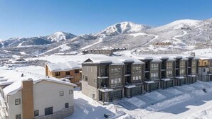 A hotel with multiple buildings, a snowy mountain backdrop, and a clear sky. - Lake and Lift Lodge at Gondola Crossing (Heber City)