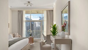 A modern hotel room with a large window, a bed, a desk, and a chair. - Waterfront Escape | Burj & Canal View | Pool+Sauna (Dubai)