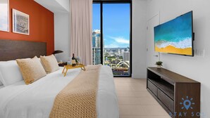 A modern hotel room with a large bed, a TV, and a city view. - 1BR Apartment with pool, gym and amenities (Miami)