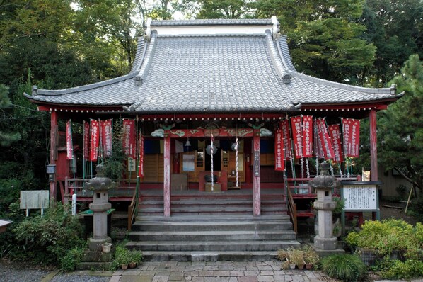 A traditional Japanese building with a tiled roof, wooden structure, and red banners. - Daruma Home Takasaki HU2 (Takasaki)