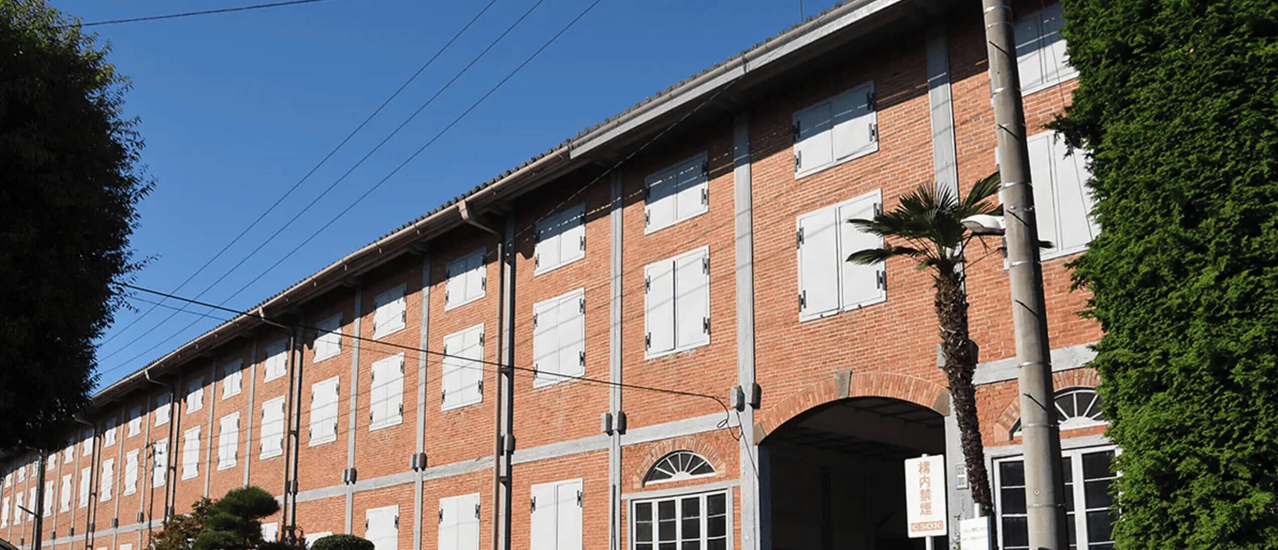A multi-story brick building with large windows and a central arched entrance.