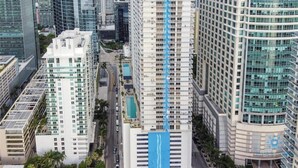 A high-rise building with a prominent blue swimming pool, surrounded by other tall buildings. - Comfortable Apartment with pool (Miami)