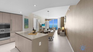 A modern kitchen with a central island, a dining area with a view, and a living space with a large window. - Bright & Spacious 2BR w/Balcony (Hollywood)