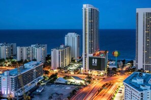 A high-rise hotel with multiple floors, a prominent 'Hyde' sign, and a view of the ocean at dusk. - Bright & Spacious 2BR w/Balcony (Hollywood)