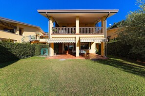A two-story building with a covered patio and a balcony. - Large apartment with lake view and swimming pool (Soiano del Lago)