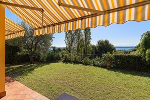 A covered outdoor area with a view of a body of water and trees. - Large apartment with lake view and swimming pool (Soiano del Lago)