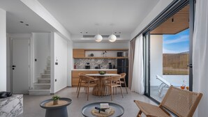 A modern kitchen with a dining area, a staircase, and a view of the outdoors. - Viridian Exclusive Villas (Sithonia)