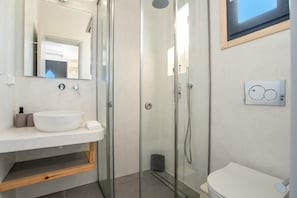 A modern bathroom with a glass shower enclosure, a white sink, and a toilet. - Studio 'Emily' with Sea View, Wi-Fi, and Air Conditioning (Παροικιά)