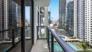 Ein Hochhaus mit Glasfassade, einem Pool und Blick auf andere Gebäude.