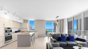 A modern apartment with a kitchen, dining area, and a balcony with a view of the ocean. - Spectacular View 2BR | Pools & Relax (Hollywood)