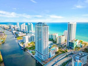 A high-rise hotel with a modern design, located near a waterfront with a view of the ocean. - 2 BR Apartment with amenities and pool |Front Ocea (Hollywood)