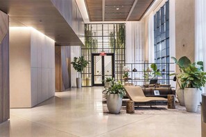 A modern lobby with a reception desk, seating area, and large windows. - New! Stylish 1BR - Amenities & Pool (Miami)