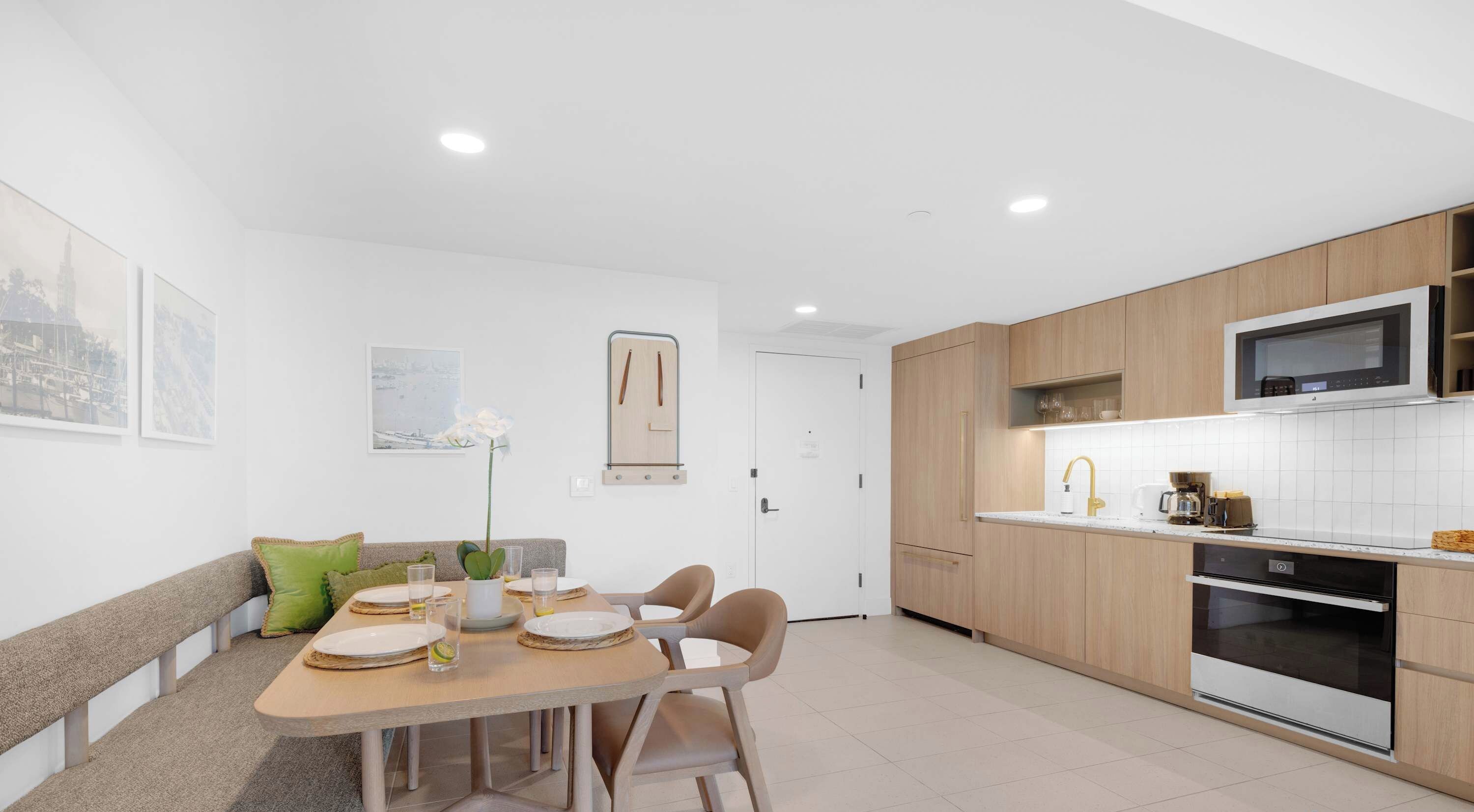 Une cuisine moderne avec des meubles en bois, un four à micro-ondes encastré et un four en acier inoxydable.