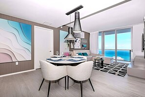 Ein modernes Wohnzimmer mit Essbereich, großen Fenstern und Meerblick.