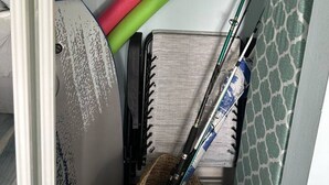 Een kamer met een bed, een plankje met een knuffel, een notitieboekje en een paar ski's die tegen de muur staan.