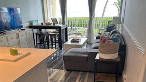 Een moderne woonkamer met een grijze bank, een klein tafeltje en een televisie.