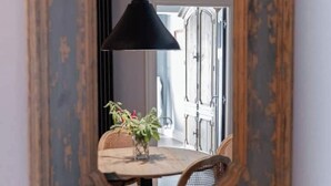 Una mesa redonda con sillas, una lámpara colgante y una planta en el centro.