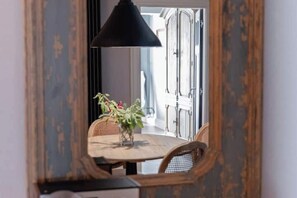 A round table with chairs, a hanging lamp, and a plant in the center. - Villa Gatta Bianca - Villa with Pool in Natural Park near Rome (Formello)