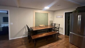 A dining area with a wooden table, benches, chairs, a refrigerator, and a kitchen counter. - Lake Access, Firepit and Kayaks (Eucha)